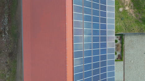 Top-down-aerial-view-of-a-building-with-solar-panels-on-the-roof