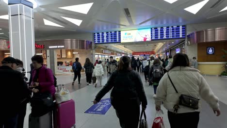 China,-Nanjing:-The-video-captures-the-inside-of-Nanjing-High-Speed-Railway-Station,-navigating-through-signage-and-the-usual-flow-of-people-while-looking-for-our-platform