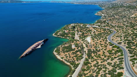 La-Vista-Aérea-Del-Cielo-Mediterráneo-Revela-Un-Barco-Oxidado-En-Medio-De-Aguas-Turquesas-Y-Un-Paisaje-Costero.