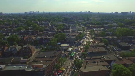 Taste-of-Italy-Along-College-Street-in-Toronto-Overhead-with-Cityscape-Views-from-a-Drone-Dolly-Shot,-Canada