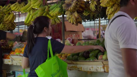 Woman-picking-avocado-at-vibrant-Indonesian-fruit-market