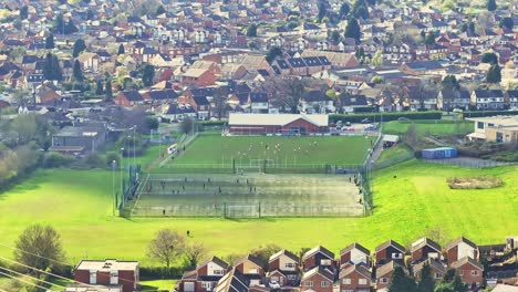 Una-Sombra-De-Una-Nube-Flota-En-El-Campo-De-Fútbol-Verde-Brillante-Donde-Los-Jugadores-Participan-En-Una-Obra