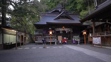 Japanese-woman-sweeping-temple-entrance-with-traditional-Japanese-broom,-japan