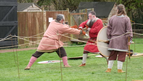 Two-men-in-historical-attire-engage-in-a-traditional-knife-fight-evoking-a-vivid-medieval-scene-reenactment