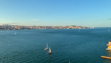 Luftaufnahme-Des-Tejo-Und-Der-Stadt-Lissabon-Mit-Segelbooten,-Die-An-Einem-Sonnigen-Sommertag-Segeln