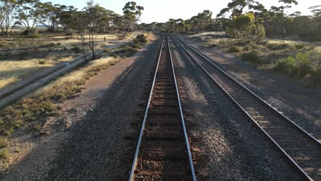 Pov-Disparó-Sobre-Las-Vías-Del-Tren-En-El-Paisaje-Tropical-De-Australia-Durante-La-Puesta-De-Sol