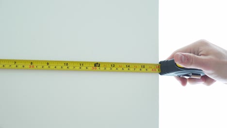 Male-hand-using-a-tape-measure-to-measure-things