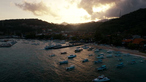 Boats-moored-in-Pantai-Padang-Bai-at-sunset,-Bali-in-Indonesia