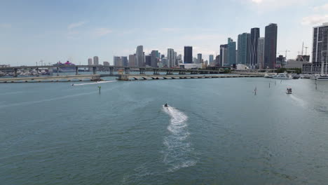 Luftaufnahme-Von-Wasserscootern-Und-Booten-In-Richtung-Der-Skyline-Von-Miami,-USA