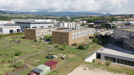 Drone-flying-away-from-a-large-elderly-care-center-with-a-green-garden