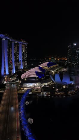 Vista-Aérea-Nocturna-De-Marina-Bay-Sands-Y-Helix-Bridge-En-Singapur,-Vertical