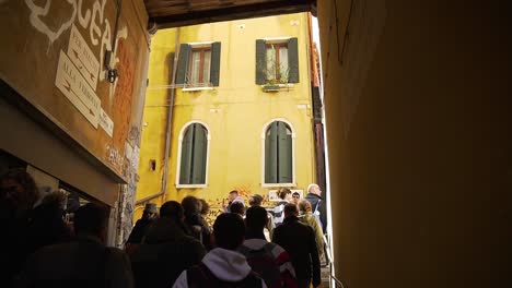 People-walking-underneath-covered-passageway-in-the-scenic-city-center-of-Venice