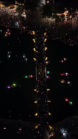 Hoi-An-Lantern-Festival,-Vietnam---people-gathering-on-Chùa-Cầu-bridge-over-Hoai-River,-vertical