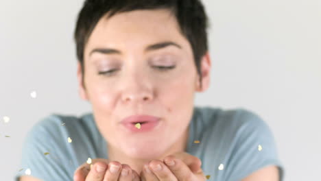 Woman-blowing-golden-glitter-out-of-her-hands-
