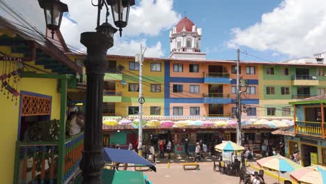 Colorful-buildings-and-a-church-tower-under-a-bright-blue-sky-in-Guatapé,-Colombia