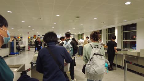 Panning-shot-of-Chinese-people-and-other-travelers-waiting-to-go-through-security-at-Brussels-airport-during-Covid-19-pandemic