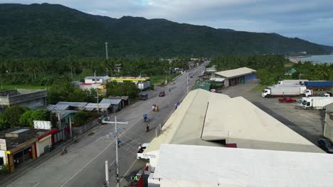 Pintoresca-Vista-Aérea-De-Una-Carretera-Muy-Transitada-Con-Motocicletas-Y-Triciclos-Conduciendo-A-Través-De-La-Pintoresca-Ciudad-De-La-Provincia-Insular-De-Virac,-Filipinas-