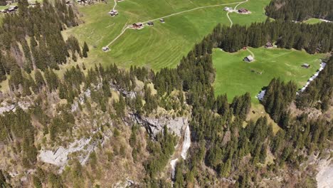 Aerial-view-of-Seerenbachfälle-in-Amden-Betlis,-Walensee,-Switzerland,-featuring-a-flat-plateau-atop-the-falls-and-steep-cliffs,-showcasing-a-blend-of-natural-tranquility-and-dramatic-landscapes