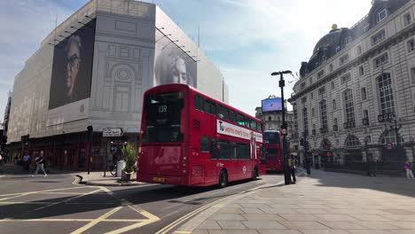 Red-Double-Decker-Buses-Driving-Past-Alojng-Coventry-Street-In-Piccadilly-Circus-On-Sunny-Morning