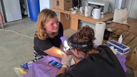 Blonde-young-girl-getting-a-homemade-tattoo-in-a-shed