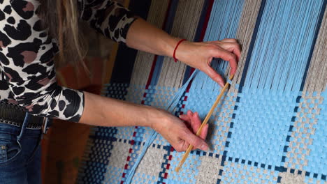 Woman-Weaving-Colorful-Blanket-on-Wooden-Frame-with-Weaving-Needle