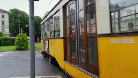 Vintage-yellow-tram-moving-through-Milan-streets,-Italy