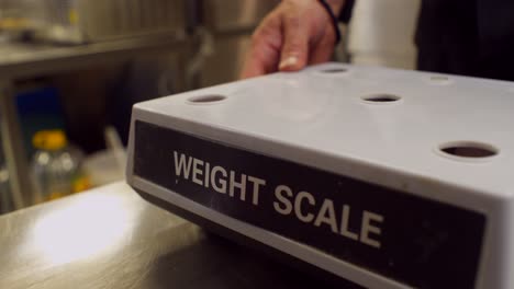 Close-up-on-man's-hands-assembling-a-kitchen-weight-scale-after-battery-replacement-and-maintenance,-4K