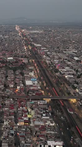 Cae-El-Anochecer,-Ecatepec-Brilla-Con-Iluminación-En-Una-Perspectiva-Vertical