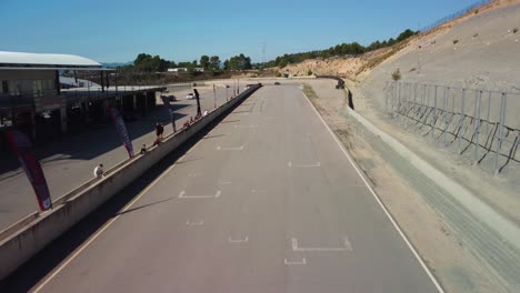 Red-car-speeding-down-the-Castelloli-Circuit-in-Barcelona-on-a-sunny-day