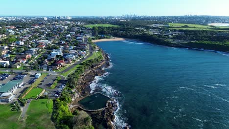 Headland-coastline-landscape-view-of-Malabar-ocean-beach-residential-neighbourhood-housing-rural-suburbs-of-Sydney-Australia-drone-aerial-travel