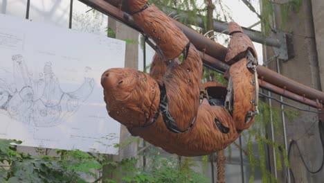 A-mechanical-sloth-crawls-along,-hanging-from-a-rod-in-the-steampunk-park-in-Nantes