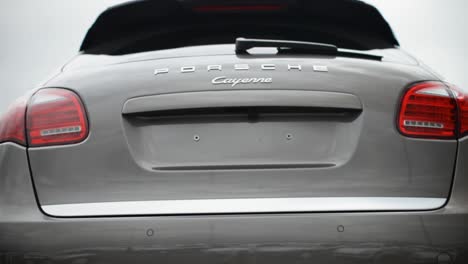 Close-up-of-a-silver-Porsche-Cayenne's-rear-in-soft-focus,-against-a-foggy-backdrop