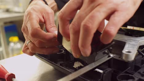 Nahaufnahme-Der-Hände-Eines-Mannes-Beim-Ersetzen-Der-Batterie-Einer-Professionellen-Küchenwaage,-Seitenansicht-4k