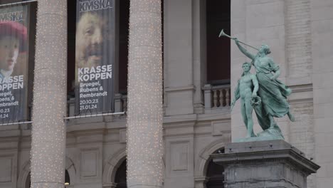 Dynamic-shot-of-sculpture-by-KMSKA-museum-in-antwerp-with-historical-building-in-the-background