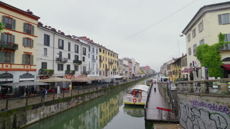 Scenic-canal-view-with-colorful-buildings-in-Milan,-Italy-on-a-cloudy-day
