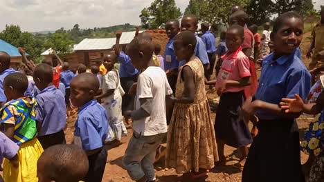 Ugandan-primary-school-students-clapping-singing-and-dancing-outside-their-school-as-they-greet-Australian-visitors