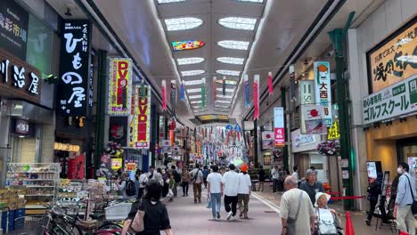 Geschäftige-Japanische-Einkaufspassage-Mit-Bunten-Schildern-Und-Herumlaufenden-Menschen