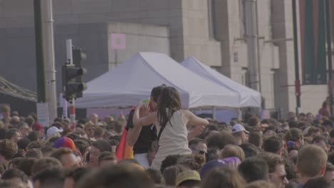 Couple-hugging-on-shoulders-at-pride-parade,-symbolizing-love-and-unity