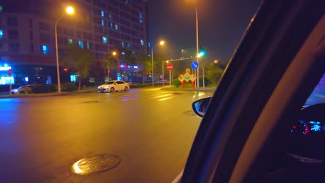 Traveling-by-taxi-at-night-through-streets-of-Beijing,-China