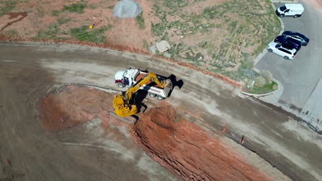 Track-hoe-loading-dump-truck-with-red-soil