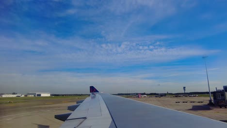 Window-view-of-another-airplane-landing-in-the-background-at-Brussels-airport,-Belgium