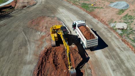 Dump-truck-departs-after-being-filled-by-excavator