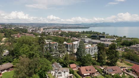 Aerial-of-beautiful-apartment-complex-surrounded-by-a-green-park-near-Lake-Geneva-in-Switzerland