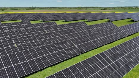 Expansive-solar-farm-with-rows-of-panels-in-a-lush-green-field-on-a-sunny-day