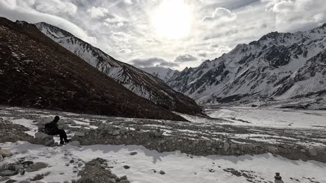 Hiker-sitting-on-a-rock-in-glacial-moraine-plains