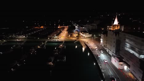 Vuelo-Nocturno-A-Lo-Largo-Del-Paseo-Marítimo-Iluminado-De-St-Peter-Port-En-Guernsey-Sobre-Victoria-Marina,-Albert-Marina-Y-Mirando-Hacia-La-Explanada-Sur-Con-La-Estatua-Del-Príncipe-Alberto