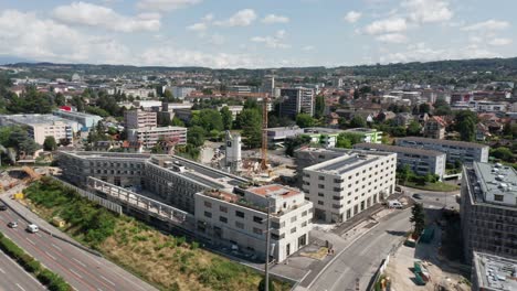 Drone-Vuela-Hacia-Un-Sitio-De-Construcción-Rodeado-De-Hermosos-Edificios-Recién-Construidos