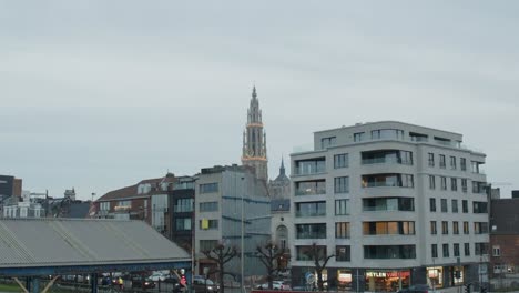 Belebte-Straße-Mit-Autos-In-Einer-Dynamischen-Aufnahme-Mit-Wohnungen-Und-Mittelalterlichem-Turm