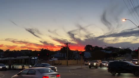Traffic-passing-under-rich-orange-suburban-sunset-in-Perth,-Western-Australia