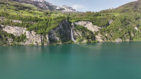 Vista-Aérea-De-Seerenbachfälle-En-Amden-Betlis,-Walensee,-Suiza,-Donde-Las-Aguas-Del-Lago-Atrapan-La-Cascada,-El-Terreno-Accidentado-De-La-Costa-Y-El-Impresionante-Paisaje-Natural.